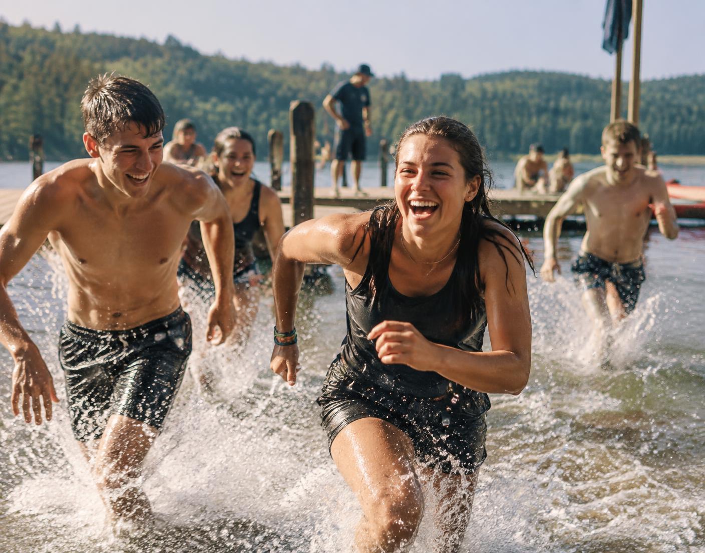 Students racing from the waterfront during a team challenge